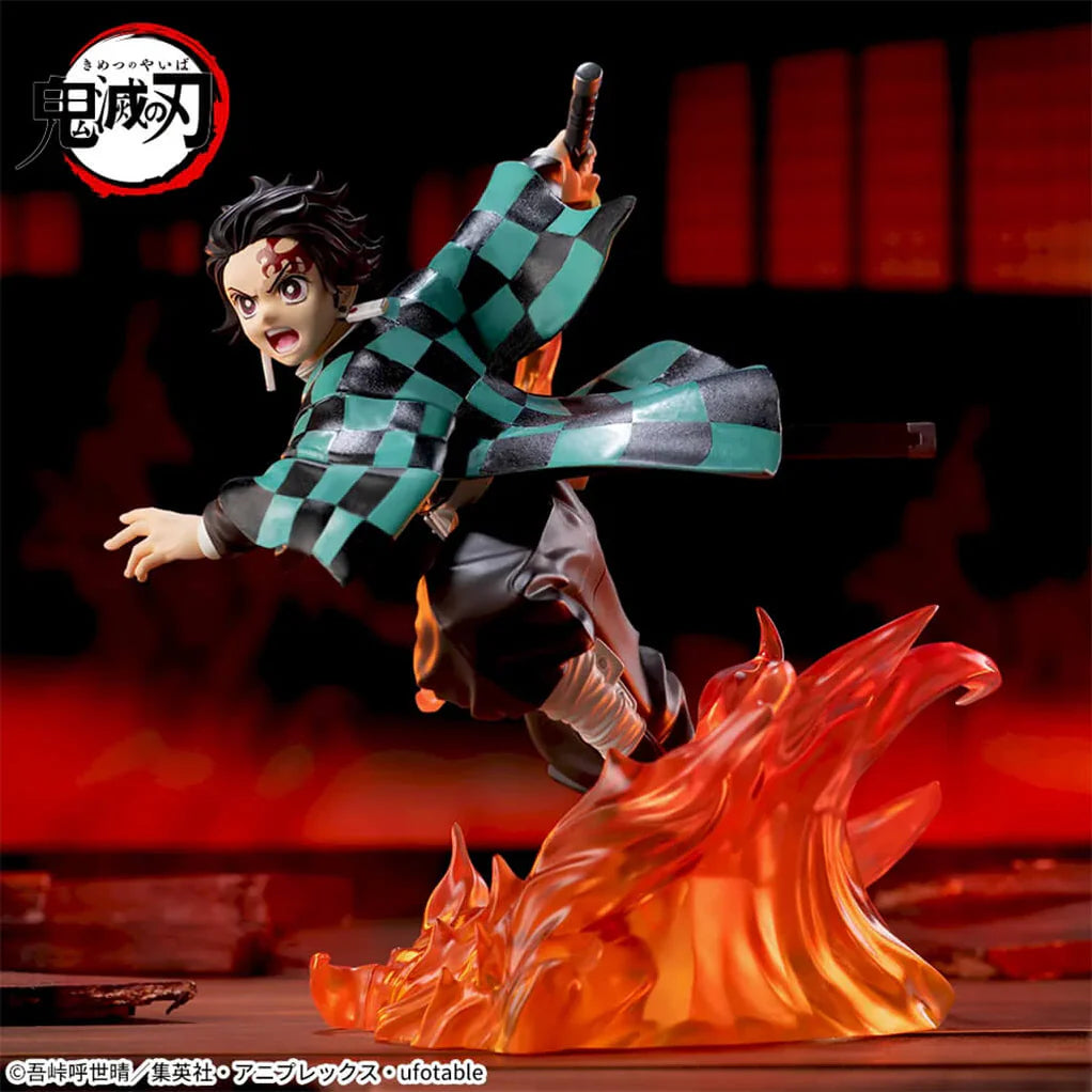 Estatua de Tanjiro Kamado de Demon Slayer, 15 cm, en pose dinámica de combate con su haori a cuadros verdes y negros, sobre una base de llamas naranjas.