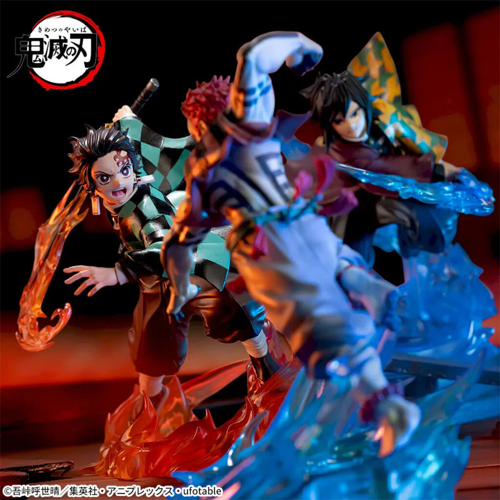 Estatua de Tanjiro Kamado en pose dinámica de combate con efectos de fuego, junto a otras figuras de Demon Slayer.