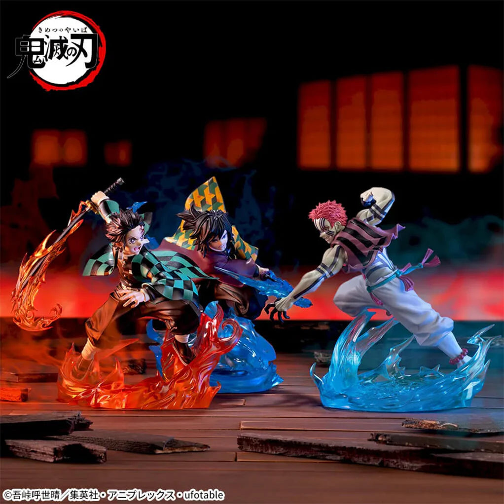 Estatua de Tanjiro Kamado en pose de combate con espada de fuego, junto a Giyu Tomioka y Akaza, sobre bases de energía.